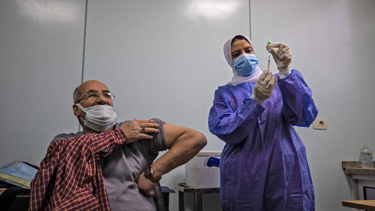 An Egyptian medical worker administers a dose of the Oxford-AstraZeneca Covid-19 vaccine (Covishield) on March 4, 2021 in Cairo on the first day of vaccination in Egypt.