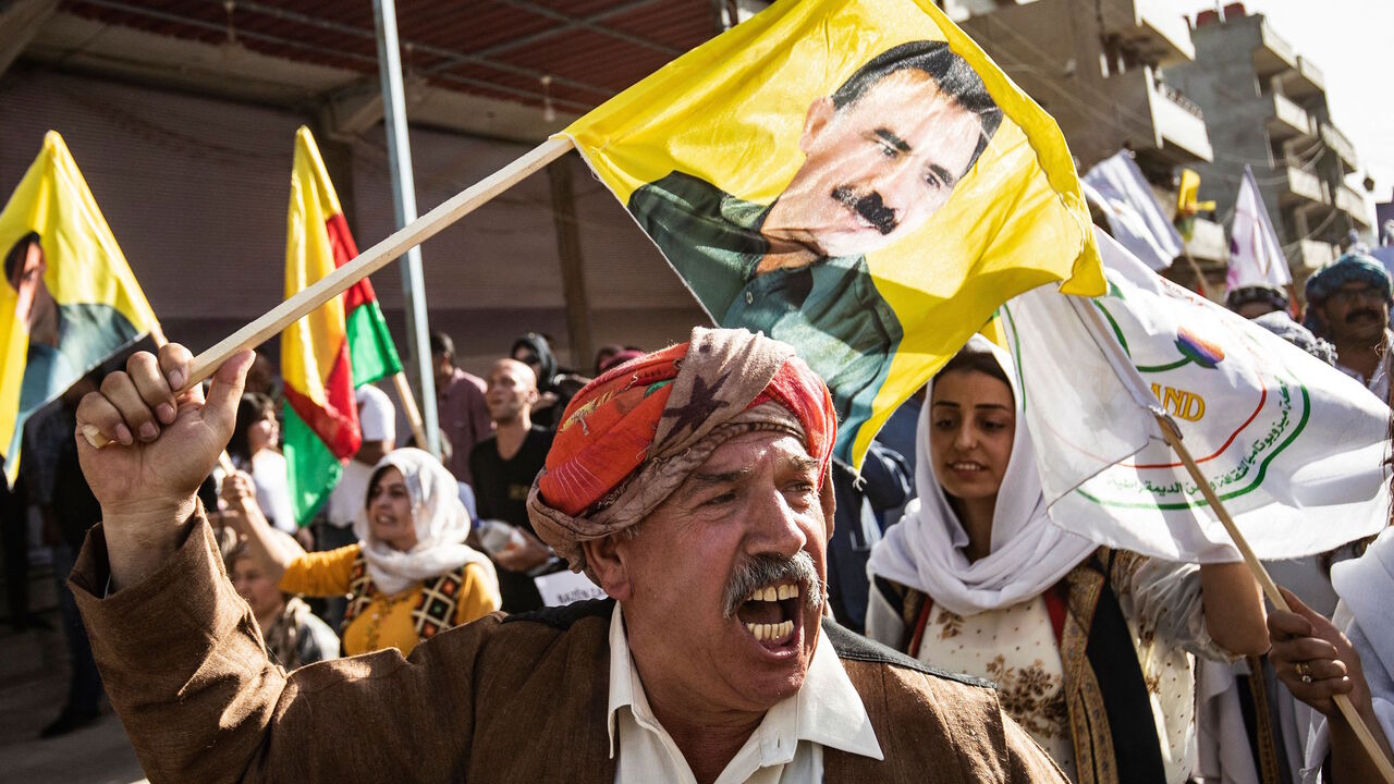 Syrian Kurds carry flags and a portrait of Kurdistan Worker's Party (PKK) leader Abdullah Ocalan as they demonstrate on June 10, 2021, in the northeastern Syrian city of Qamishli, against the Turkish offensive on PKK areas in northern Iraq.