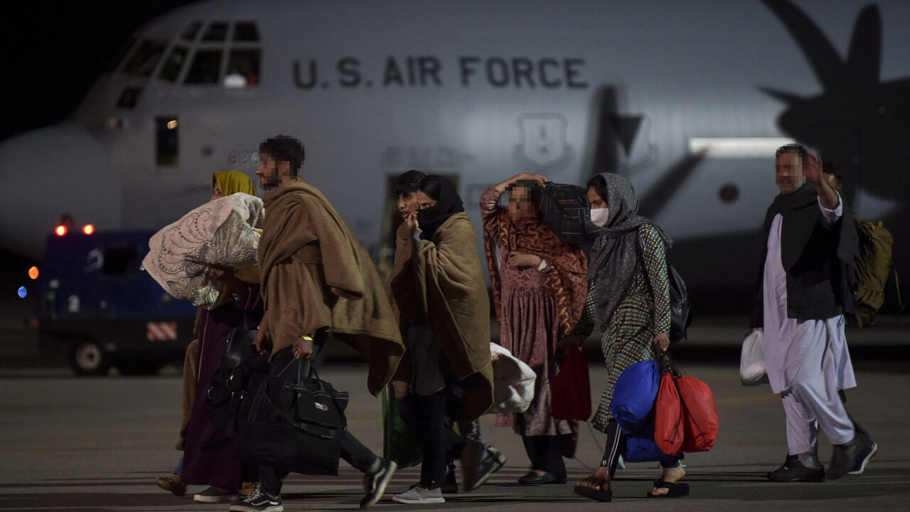 Afghan refugees, fleeing the Afghan capital Kabul, exit an US air force plane upon their arrival at Pristina International airport near Pristina on Aug. 29, 2021.