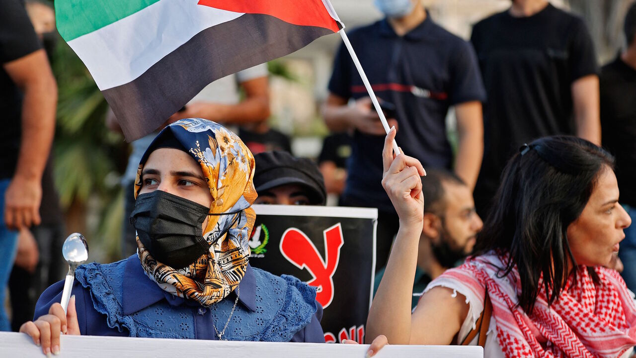 Arab Israeli protesters lift Palestinian flags and spoons, reportedly the digging tool used by six Palestinian prisoners who escaped from Israel's Gilboa prison, as they demonstrate in the mostly Arab city of Umm al-Fahm in northern Israel, on Sept. 10, 2021, to denounce punitive measures taken by the Israel Prison Service against Palestinian prisoners following the jailbreak. 