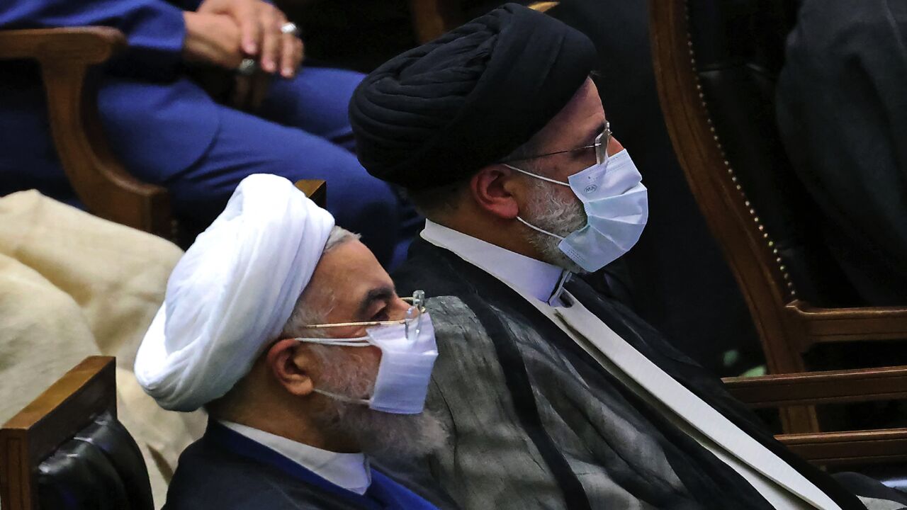 Iran's outgoing president, Hassan Rouhani (L), attends the swearing-in ceremony for newly elected President Ebrahim Raisi (R).