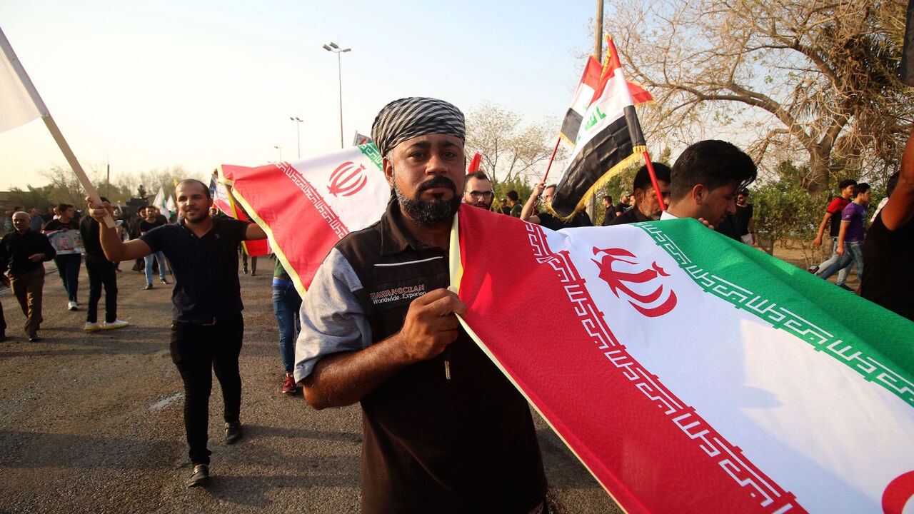 Demonstrators hold Iranian flags during a protest on Sept. 15, 2018, against the torching of the Iranian Consulate and the Hashed al-Shaabi party (Popular Mobilisation) headquarters during recent protests in the southern Iraqi city of Basra.