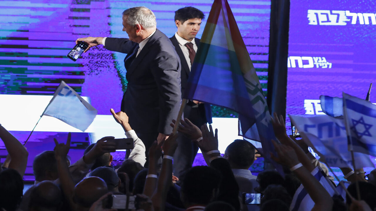 Retired Israeli Gen. Benny Gantz, one of the leaders of the Blue and White party, uses a cellphone to take a selfie photograph with supporters during a campaign event, Tel Aviv, Israel, April 7, 2019.