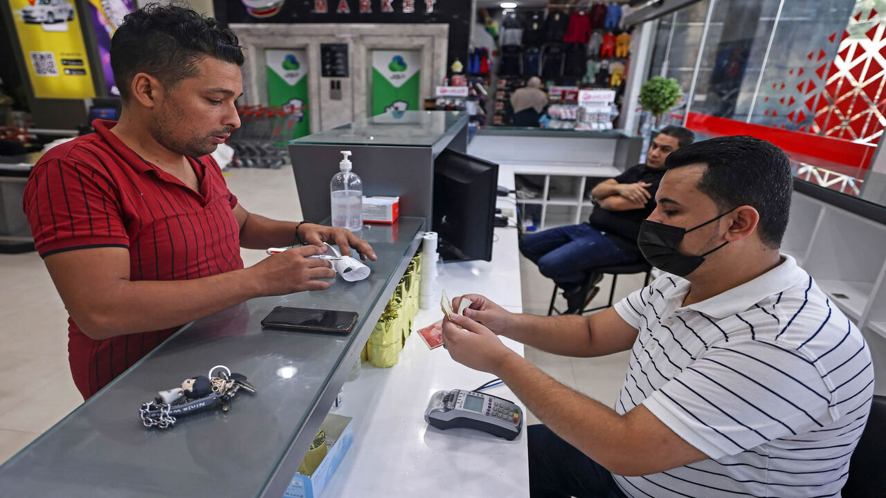 A Palestinian man receives financial aid at a supermarket as part of the United Nations Humanitarian Cash Assistance program, supported by Qatar, Gaza City, Gaza Strip, Sept. 15, 2021.