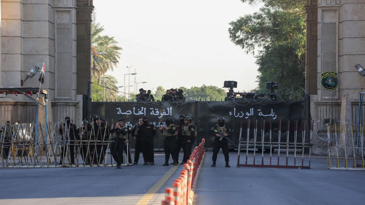 Members of Iraqi security stand guard as supporters of the Hashid al-Shaabi paramilitary network march toward one of the Green Zone entrances in the capital, Baghdad, on Nov. 6, 2021.