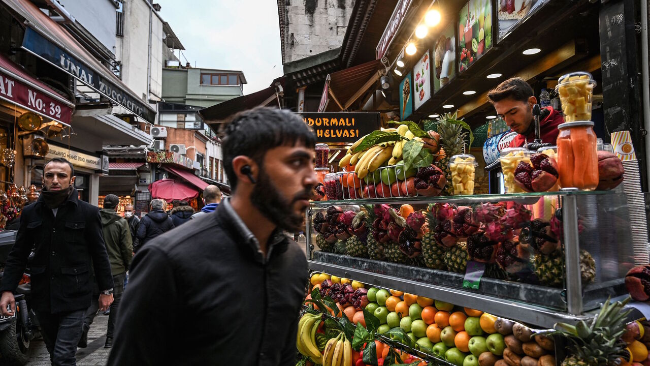 A man walks past a fruit seller at Eminonu district near Spice Bazaar in Istanbul, on Nov. 24, 2021. 