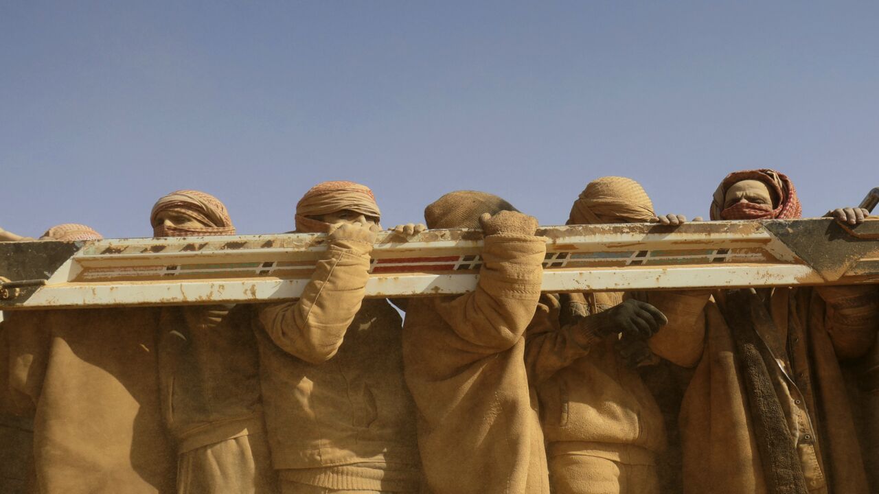 Men standing in the back of a truck after fleeing battles between SDF and IS in the Syrian village of Baghuz arrive after crossing a desert to a region controlled by the SDF in Deir ez-Zor on Jan. 26, 2019.