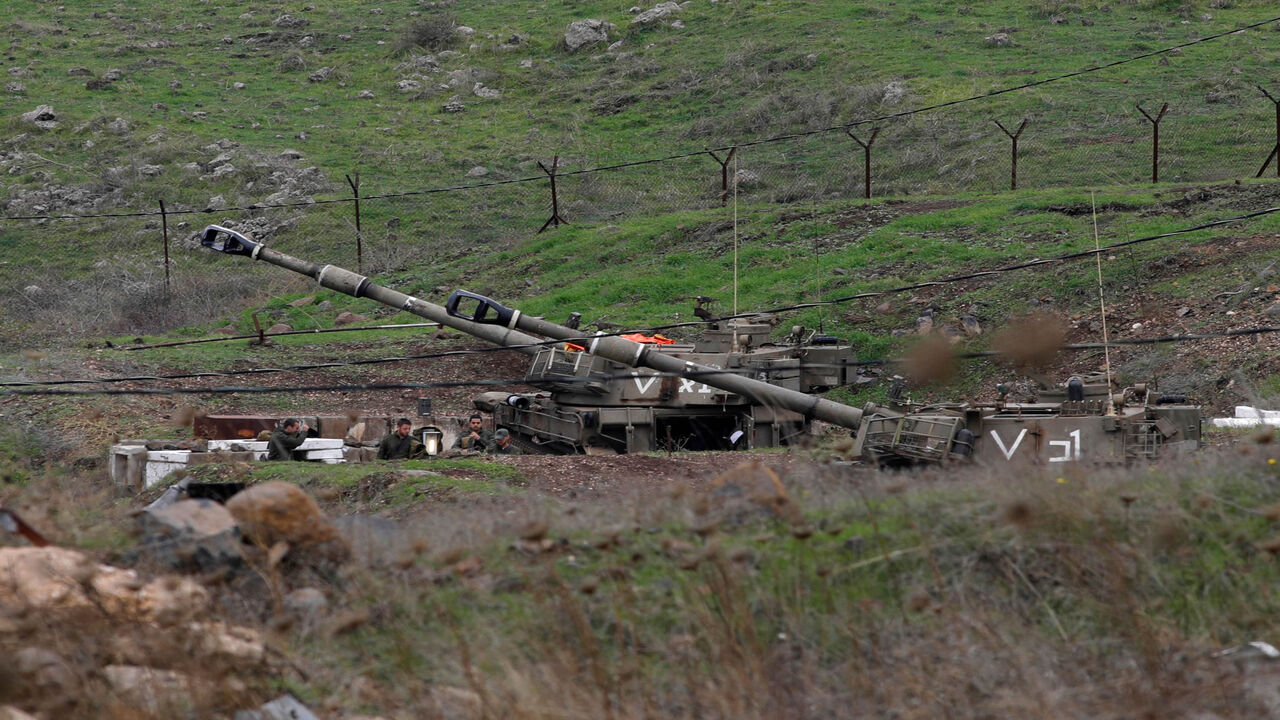 Israeli solders gather next to self-propelled Howitzers in the Israeli-annexed Golan Heights on the border with Syria, Nov. 28, 2020.