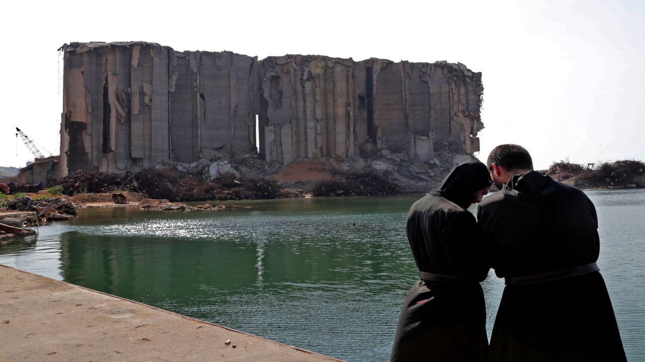 Maronite clergymen pray near damaged grain silos at the port of Lebanon's capital on Aug. 4, 2021.