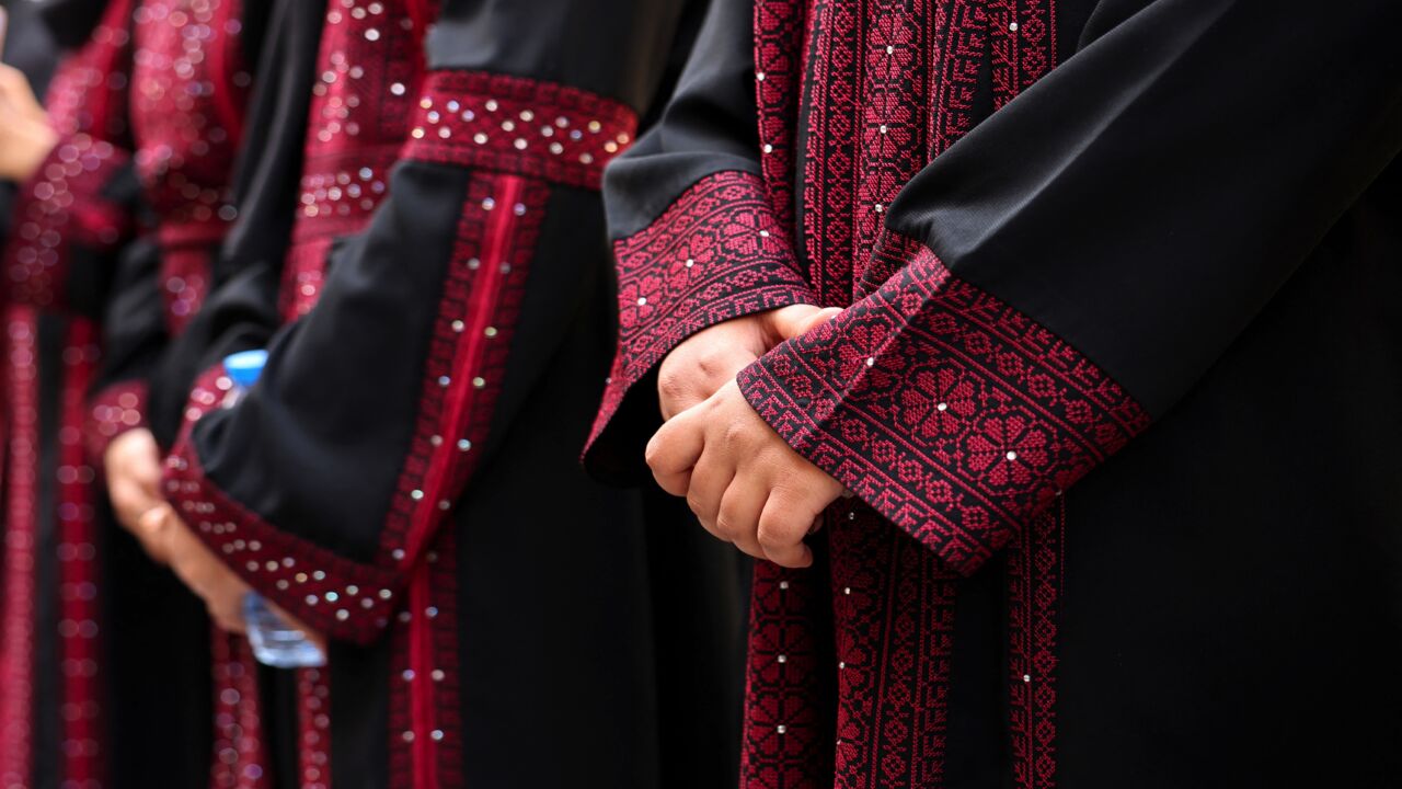 Palestinian university students wearing traditional embroidered dresses take part in an event entitled "Don't Steal Our Heritage" in Gaza City, on Dec. 16, 2021.