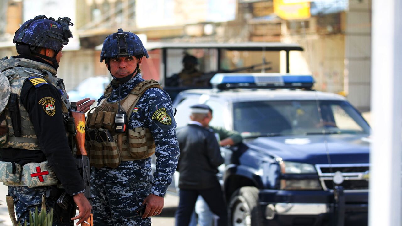 Members of the Iraqi federal police force stand guard at a checkpoint in Baghdad, on January 29, 2021.