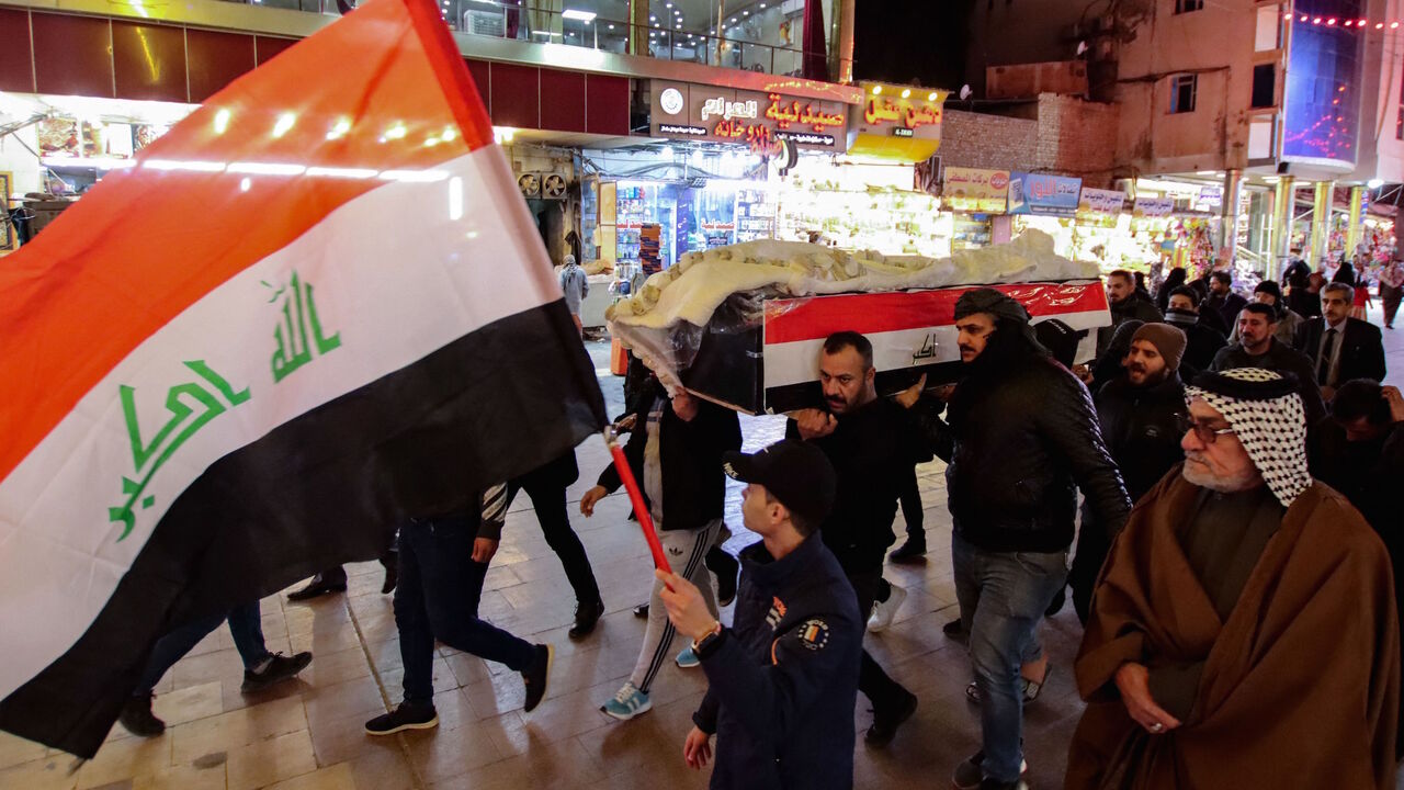 Mourners carry the casket of one of eleven Iraqi soldiers, killed in an overnight attack by the Islamic State (IS) group against a base in eastern Iraq, through a street in the central holy shrine city of Najaf, on Jan. 21, 2022.