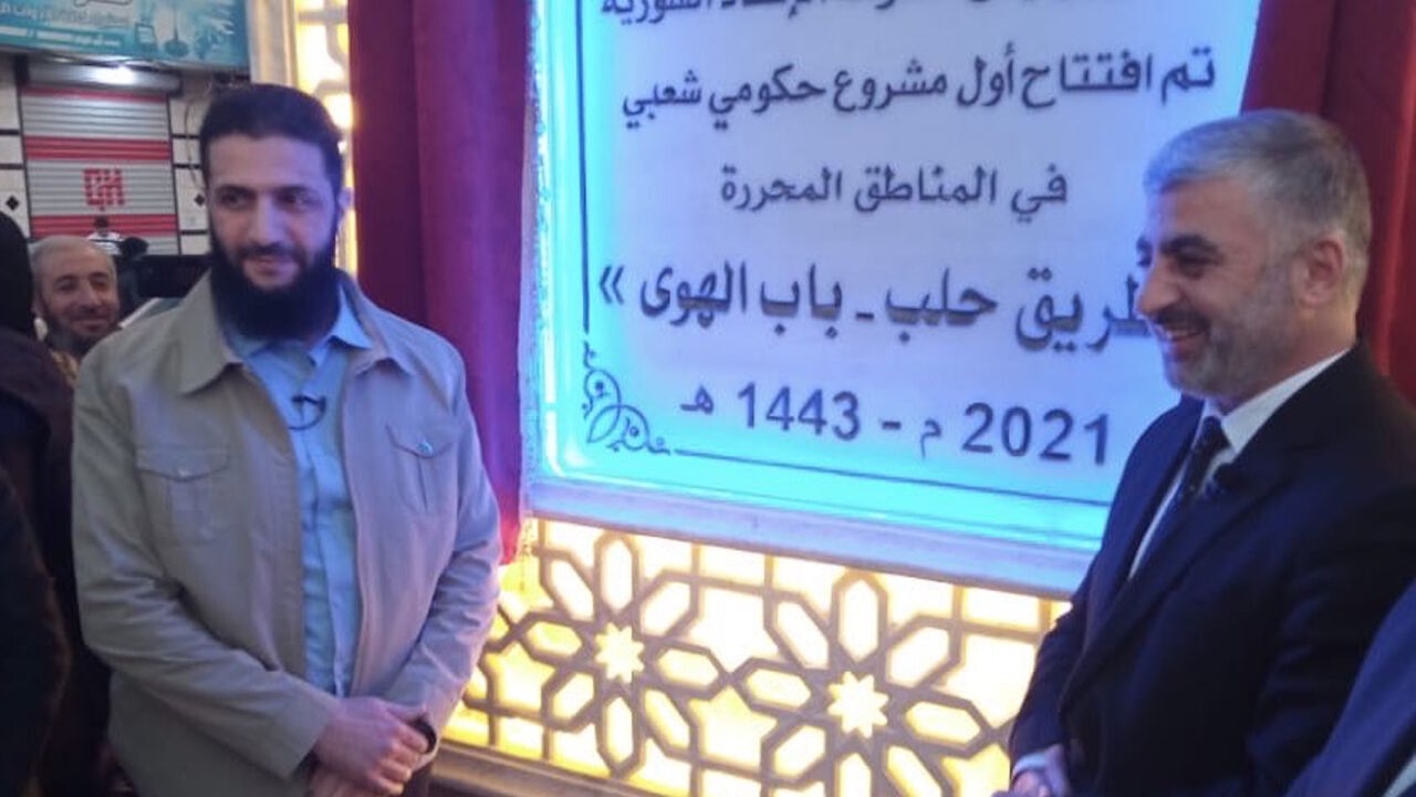 Abu Mohammed al-Golani (L) and the HTS-affiliated government's Prime Minister Ali Keda appear at an opening ceremony for the Aleppo-Bab al-Hawa road, Jan. 7.