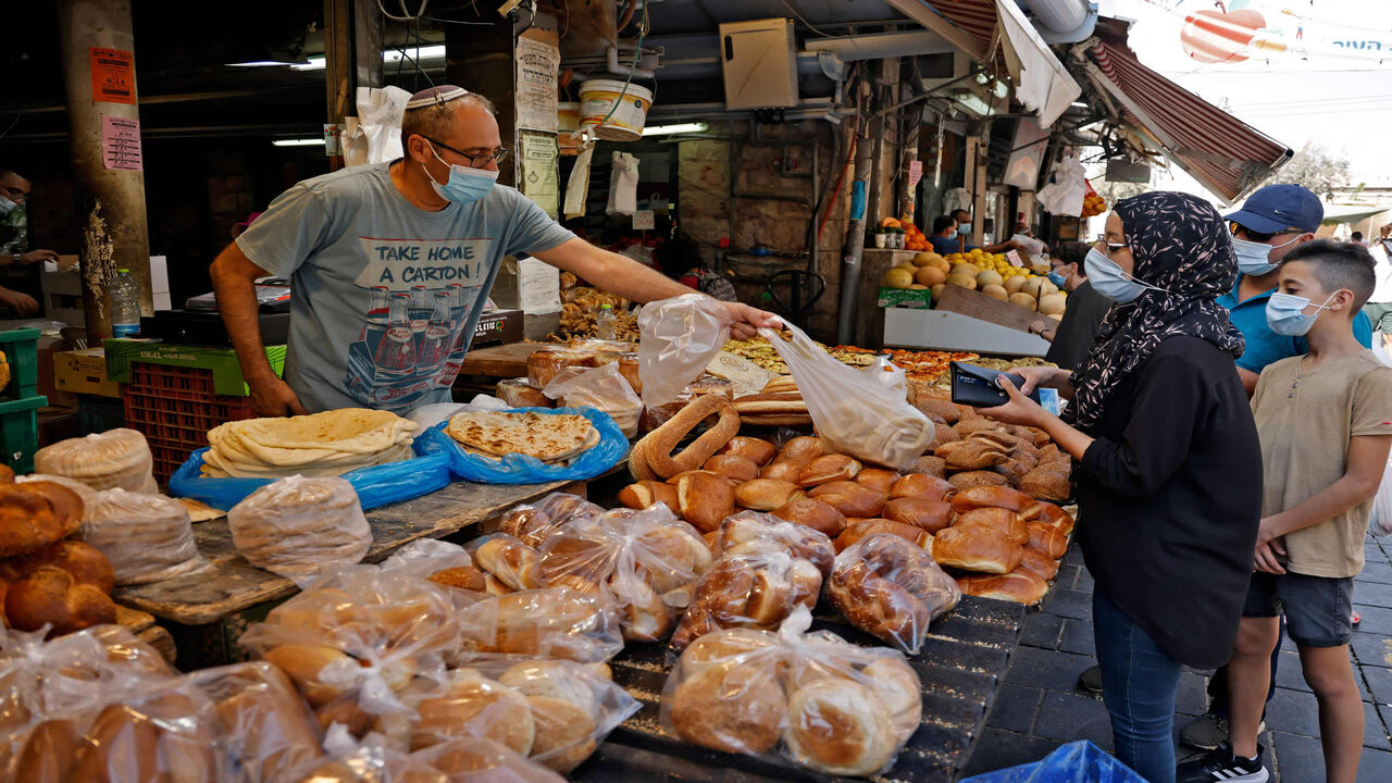 Shoppers buy bread at the Mahane Yehuda market, a day ahead of a nationwide lockdown aimed at curbing a surge in coronavirus cases, Jerusalem, Sept. 24, 2020.