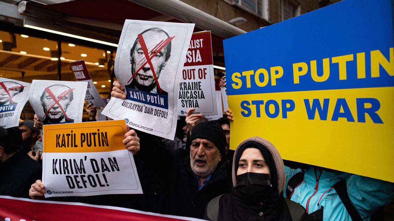 Demonstrators hold placards during a protest against Russia's military operation in Ukraine in front of the Russian embassy in Istanbul on February 24, 2022. - Russia's President has launched a military operation in Ukraine on February 24, 2022 after weeks of intense diplomacy and the imposition of Western sanctions on Russia that failed to deter him. (Photo by Yasin AKGUL / AFP) (Photo by YASIN AKGUL/AFP via Getty Images)