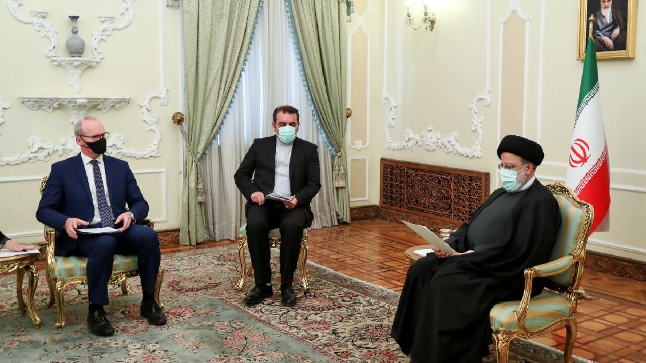 A handout picture provided by the Iranian President Ebrahim Raisi's office shows him (R) with Irish Foreign Minister Simon Coveney (L) in the capital Tehran A handout picture provided by the Iranian President Ebrahim Raisi's office shows him (R) with Irish Foreign Minister Simon Coveney (L) in the capital Tehran