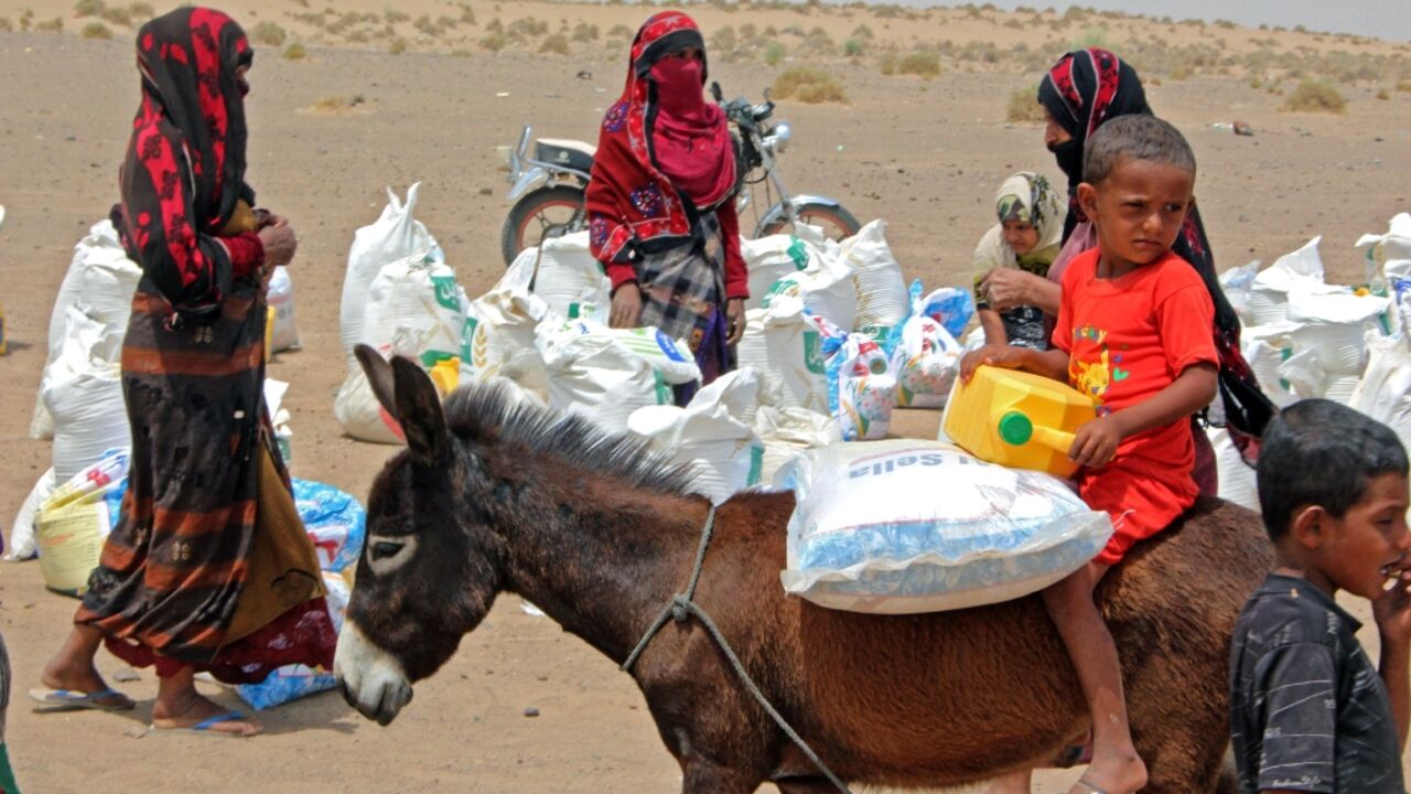 Yemeni families receive flour rations and other basic food supplies from charities in the province of Lahj, in southern Yemen, on March 29, 2022