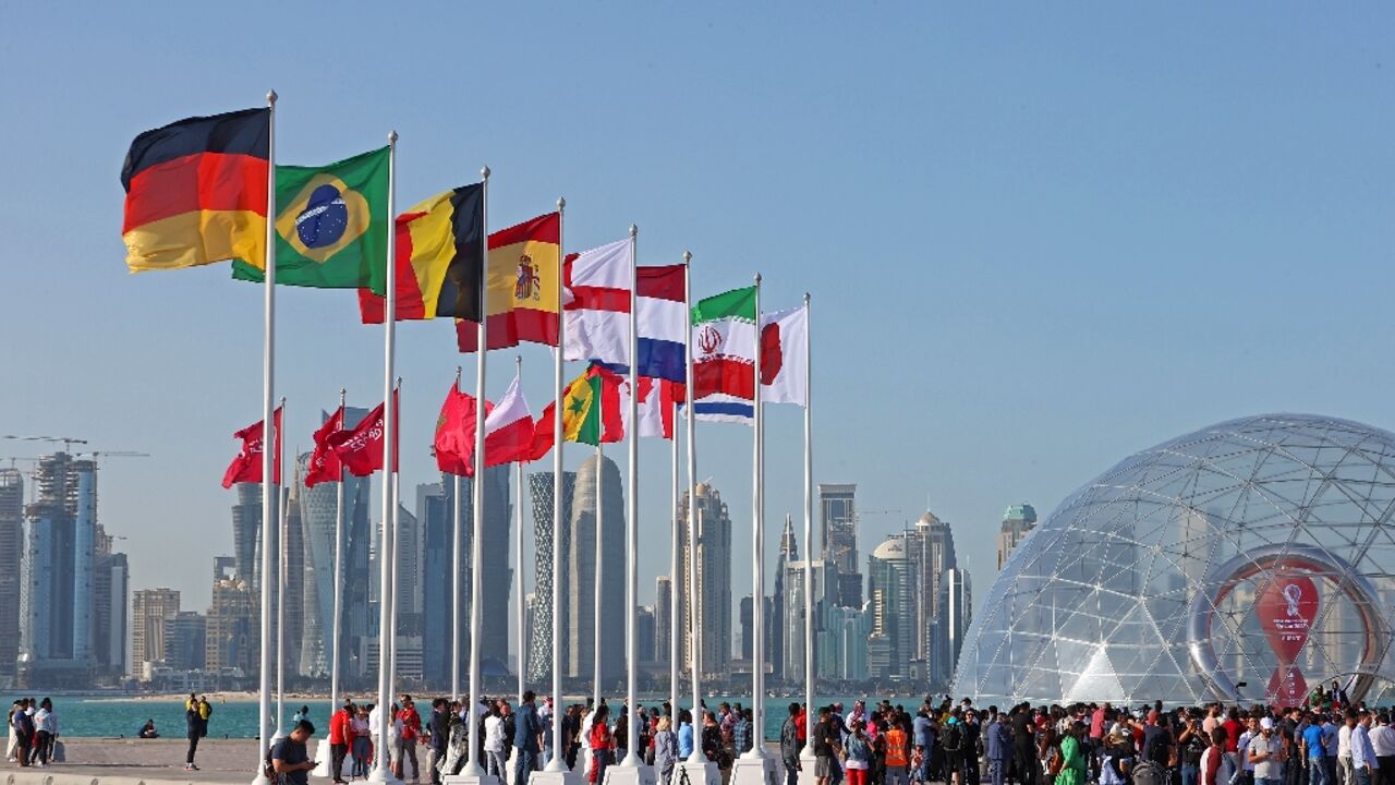 Flags of the countries qualified for this year's World Cup flutter on the seafront in Doha