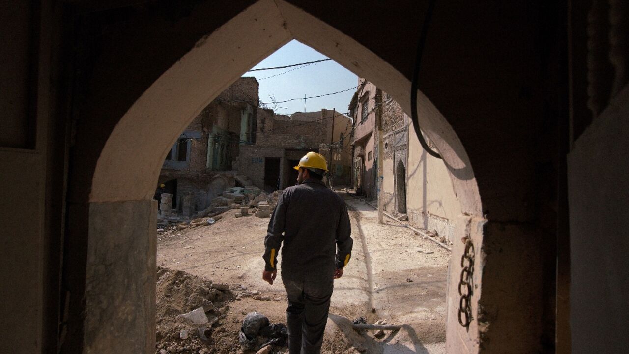 An Iraqi architect exits a traditional house during renovations in the Old Town of Mosul, which was reduced to rubble during fighting to expel jihadists