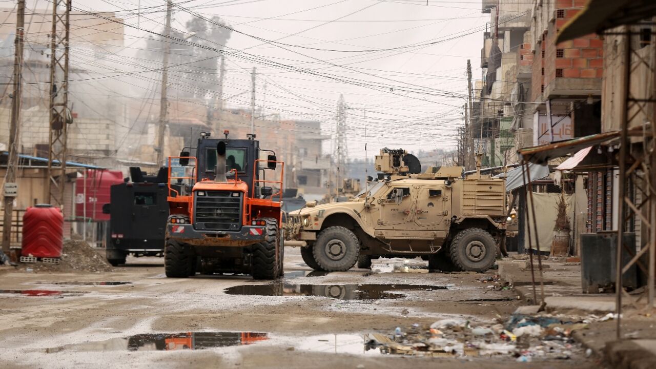 US soldiers accompanied by members of the Syrian Democratic Forces (SDF) gather in Ghwayran area of Hasakeh city on January 29, 2022 during a search for escaped prisoners believed to be affiliated with IS