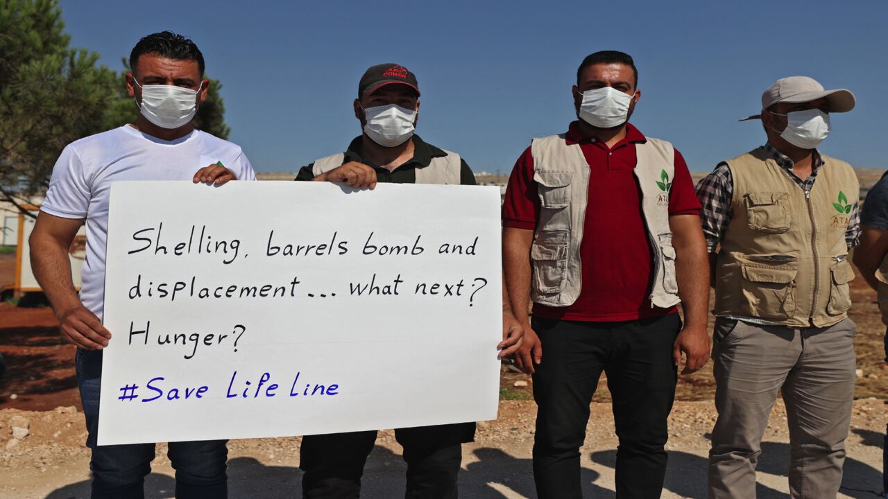 A human chain is formed by workers from the civil society, humanitarian aid, and medical and rescue services.