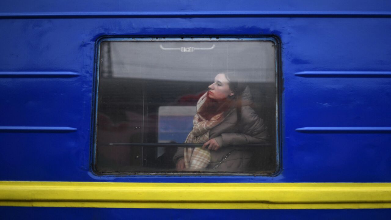 A woman arriving from Odessa looks out from a carriage window at a train station in Lviv, western Ukraine, as she prepares to continue her journey to Slovakia on March 3, 2022.