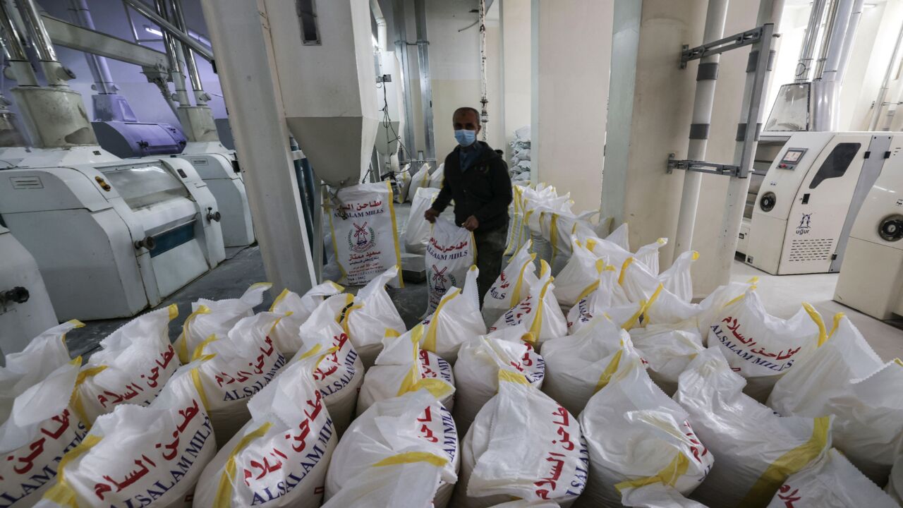 A Palestinian employee works inside a wheat mill.