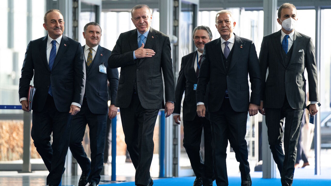 Turkey's President Recep Tayyip Erdogan (C) walks with officials, including Turkey's Foreign Minister Mevlut Cavusoglu