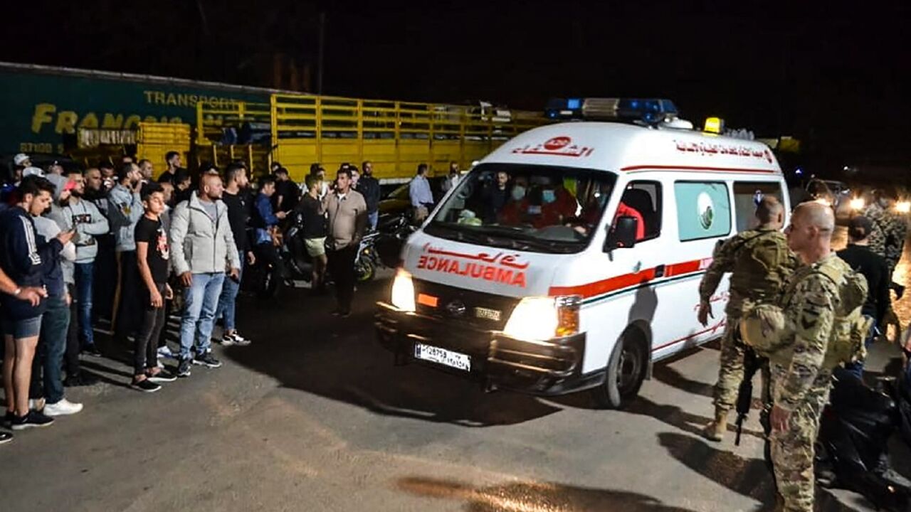 Lebanese soldiers and onlookers stand at the entrance of the port of Tripoli, as an ambulace carries survivors from a boat that sank off the northern city Lebanese soldiers and onlookers stand at the entrance of the port of Tripoli, as an ambulace carries survivors from a boat that sank off the northern city