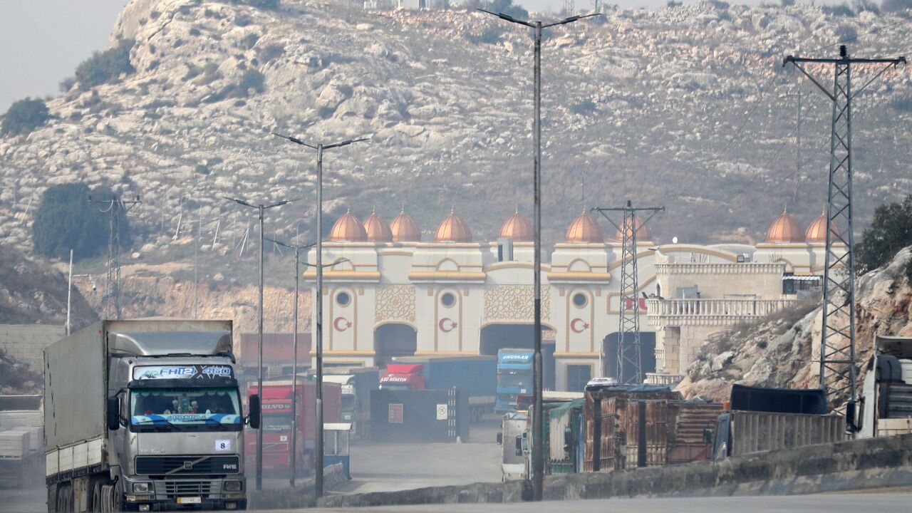 A convoy transporting humanitarian aid crosses into Syria from Turkey through the Bab al-Hawa border crossing on Jan. 18, 2022. 