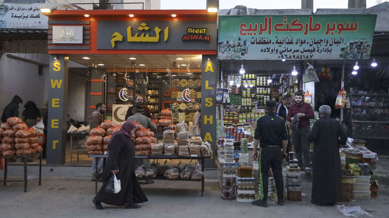 Syrians buy food supplies ahead of the Muslim month of Ramadan, at a shopping street in the northwestern rebel-held city of Idlib, on April 1, 2022.