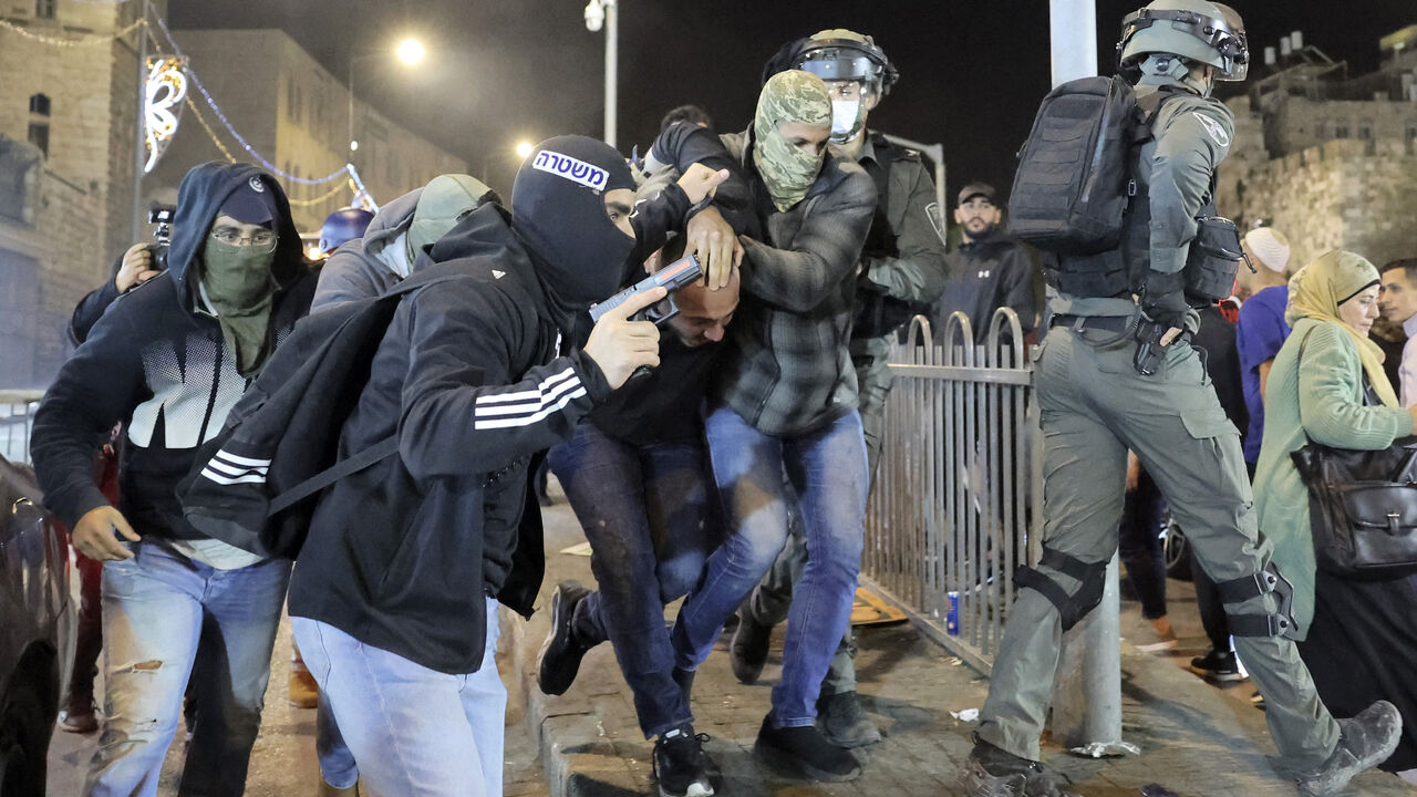 Israeli security forces detain a Palestinian man outside the Damascus Gate of the old city of Jerusalem late on April 3, 2022. 