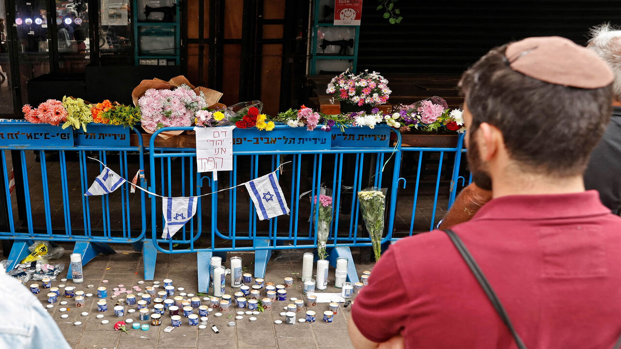 Israelis light candles at the site of a shooting attack the previous night at Dizengoff Street in the center of Tel Aviv, Israel, April 8, 2022.