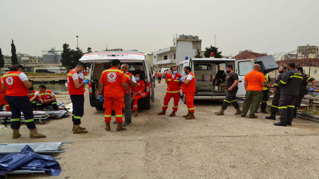 Medics wait on the pier as soldiers search for survivors off the coast of Tripoli, after an overloaded migrant boat capsized during a chase by naval forces, Lebanon, April 24, 2022.