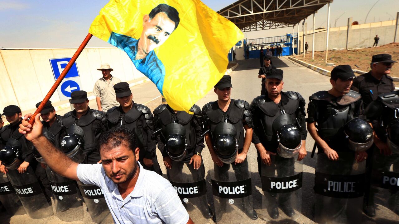 An Iraqi Kurdish supporter of the Kurdistan Workers Party (PKK) waves a flag bearing the portrait of Kurdish rebel leader Abdullah Ocalan.