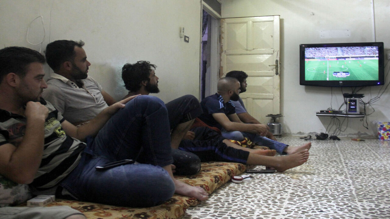 Syrian men watch the FIFA World Cup 2018 qualification soccer game between Iran and Syria, played in Tehran, in the rebel-held town of Binnish on the outskirts of Idlib, Syria, Sept. 5, 2017.