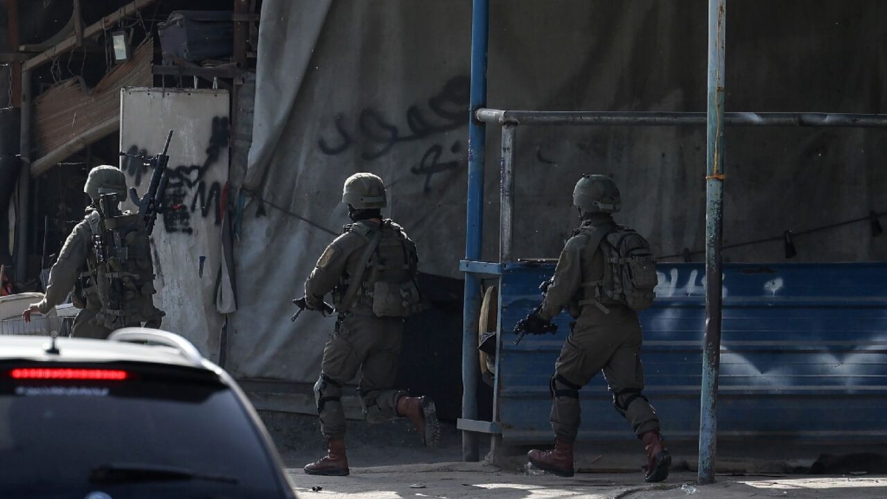 Israeli troops take position in the Nur Shams Palestinian refugee camp near in the northern West Bank town of Tulkarem during a raid looking for suspects related to a Palestinian suspect blamed for a shooting that killed three Israelis in Tel Aviv Israeli troops take position in the Nur Shams Palestinian refugee camp near in the northern West Bank town of Tulkarem during a raid looking for suspects related to a Palestinian suspect blamed for a shooting that killed three Israelis in Tel Aviv