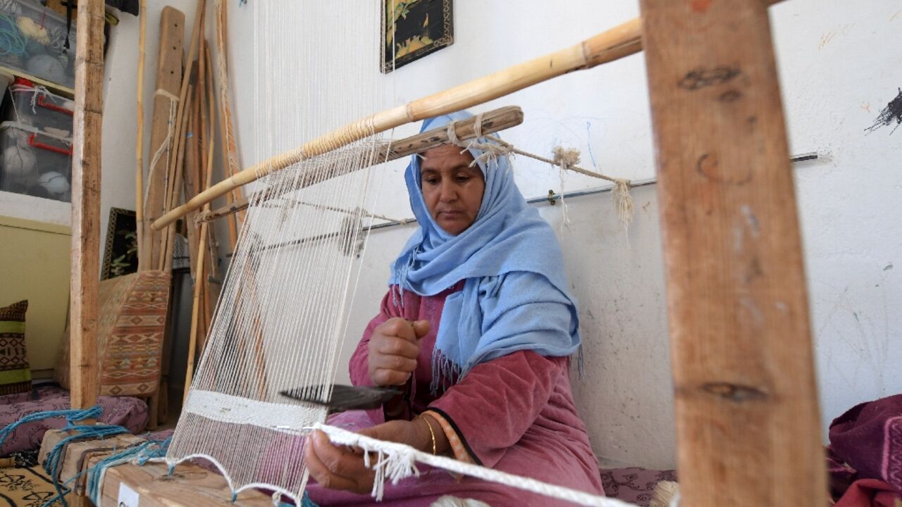 A Tunisian craftswoman weaves a rug at a workshop run by Shanti, a social enterprise that helps artisans from across the North African country