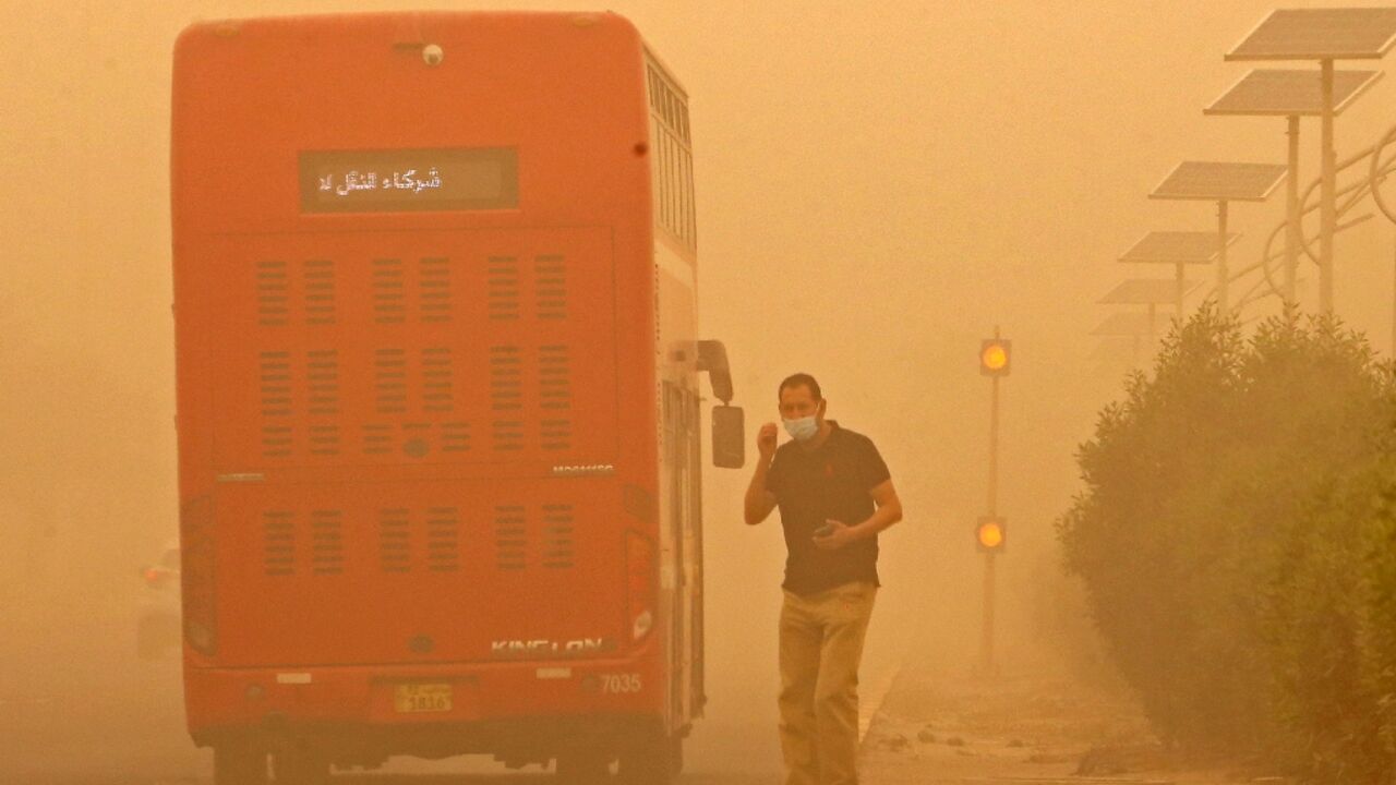 A commuter in Kuwait City waits to cross a street amid heavy sandstorms that have engulfed the Middle East A commuter in Kuwait City waits to cross a street amid heavy sandstorms that have engulfed the Middle East
