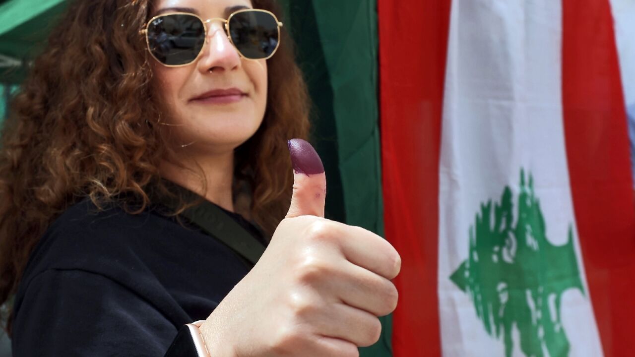 A Lebanese woman displays her ink-stained finger after voting at the Lebanese embassy in Riyadh