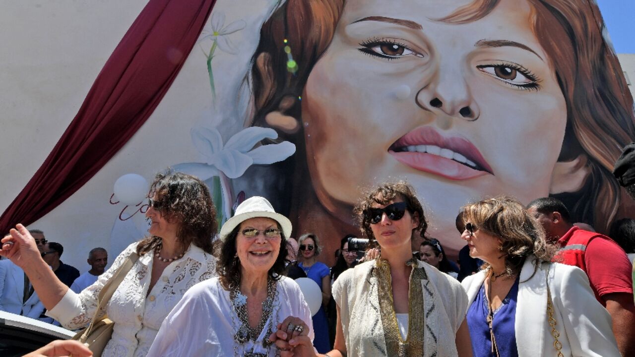 Italian-Tunisian actress Claudia Cardinale (2nd-L) poses in front of a mural of her during a street naming ceremony in her honour in Tunisia Italian-Tunisian actress Claudia Cardinale (2nd-L) poses in front of a mural of her during a street naming ceremony in her honour in Tunisia