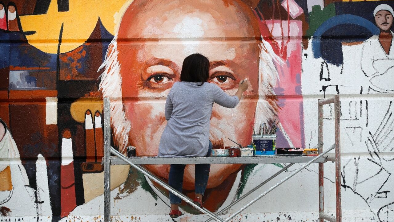 Perched on a scaffold at a busy intersection, 49-year-old Wijdan al-Majed adds final touches to a Baghdad mural dedicated to celebrated Iraqi poet Muzzafar al-Nawab Perched on a scaffold at a busy intersection, 49-year-old Wijdan al-Majed adds final touches to a Baghdad mural dedicated to celebrated Iraqi poet Muzzafar al-Nawab