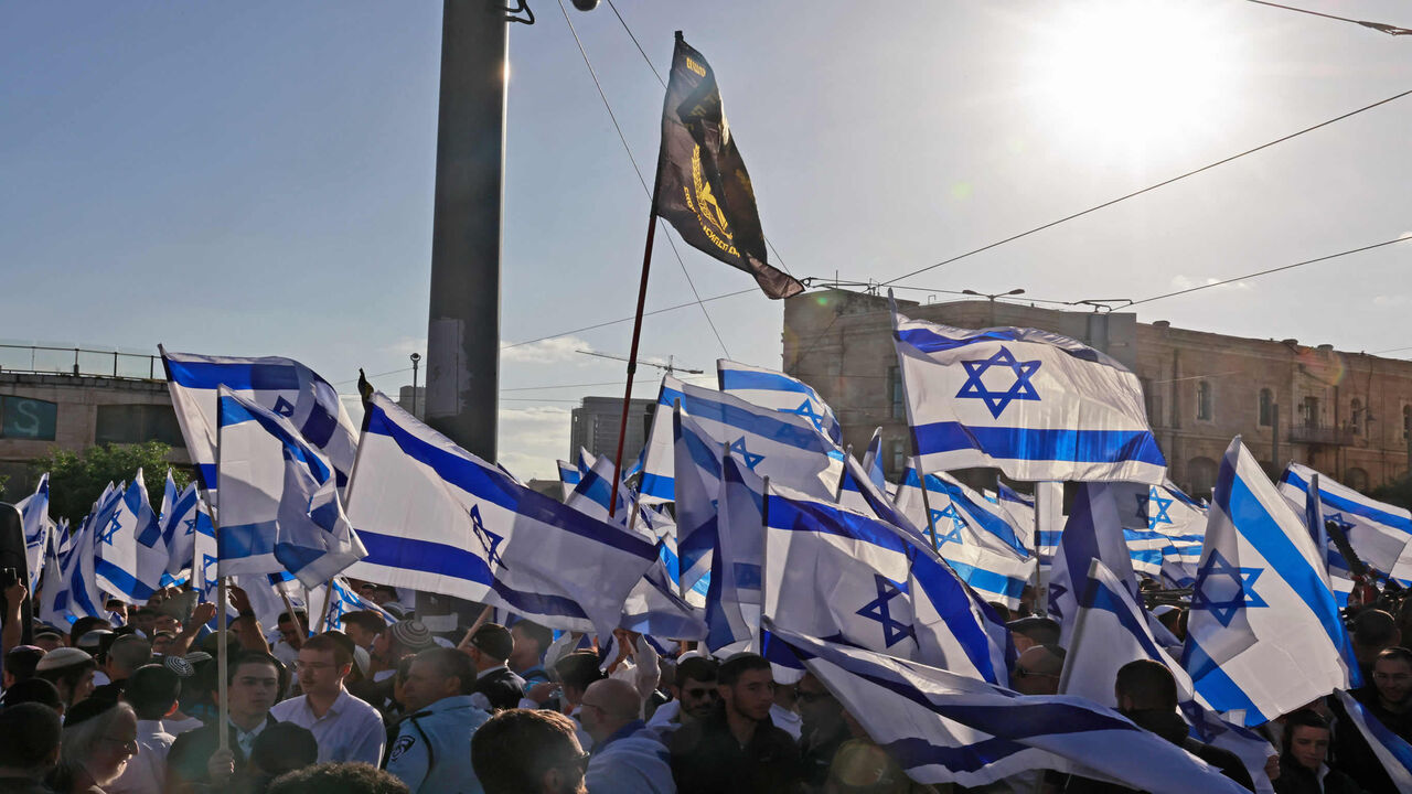 Israeli protesters wave national flags as they march toward Tzahal Square during the Flag March organized by nationalist parties, Jerusalem, April 20, 2022.