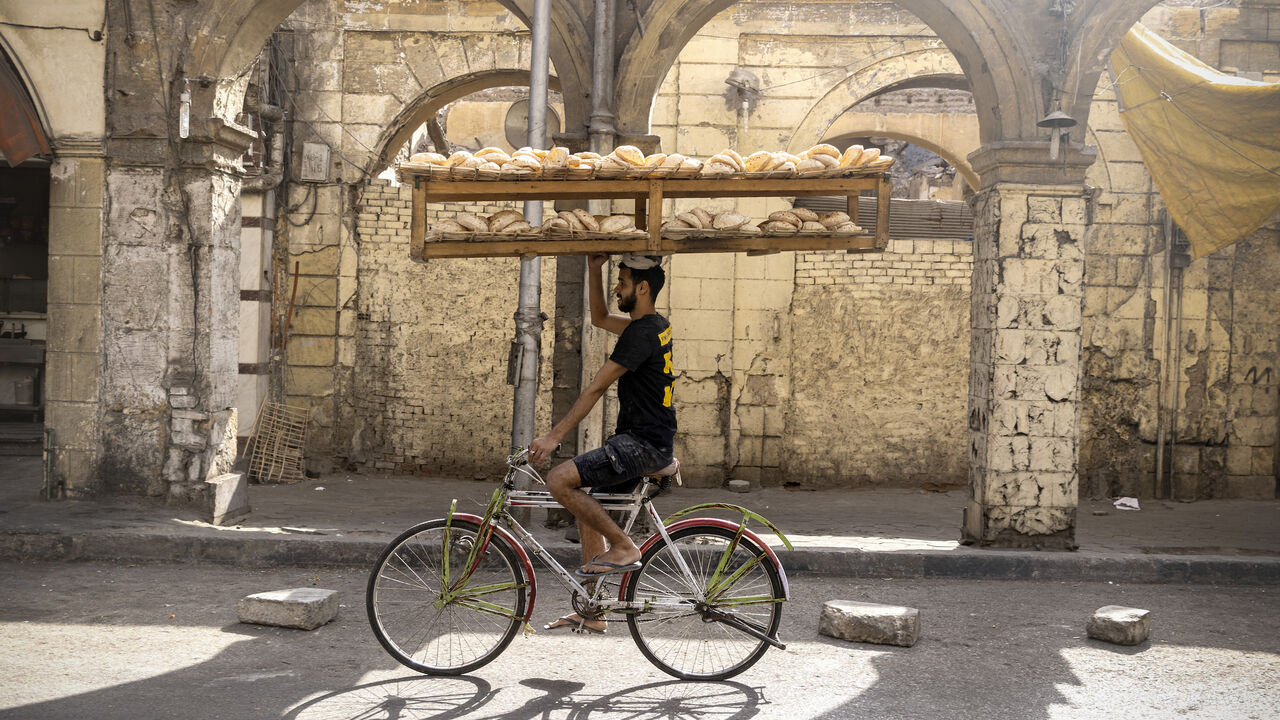 Workers on bikes deliver Egyptian traditional Baladi bread.