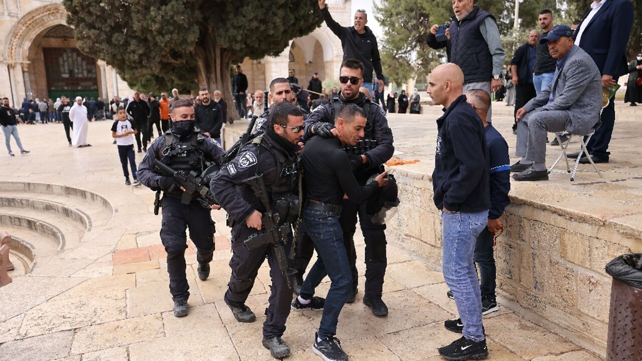 Israeli police restrain a Palestinian protester as security forces accompany a group of Jewish visitors past the Dome of the Rock at the Al-Aqsa mosque compound in the Old City of Jerusalem on May 5, 2022 Israeli police restrain a Palestinian protester as security forces accompany a group of Jewish visitors past the Dome of the Rock at the Al-Aqsa mosque compound in the Old City of Jerusalem on May 5, 2022