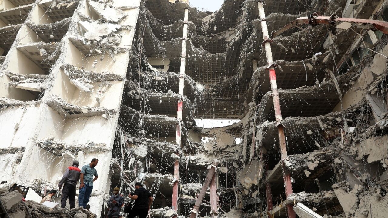 Iranians gather at the site where a 10-storey building collapsed as rescue operations continue in the southwestern city of Abadan