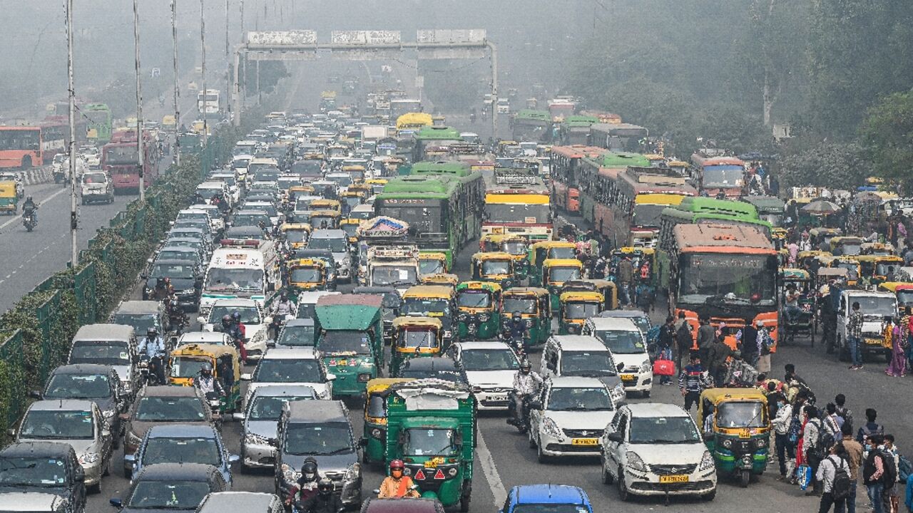 Commuters make their way along a busy road under heavy smoggy conditions in New Delhi 