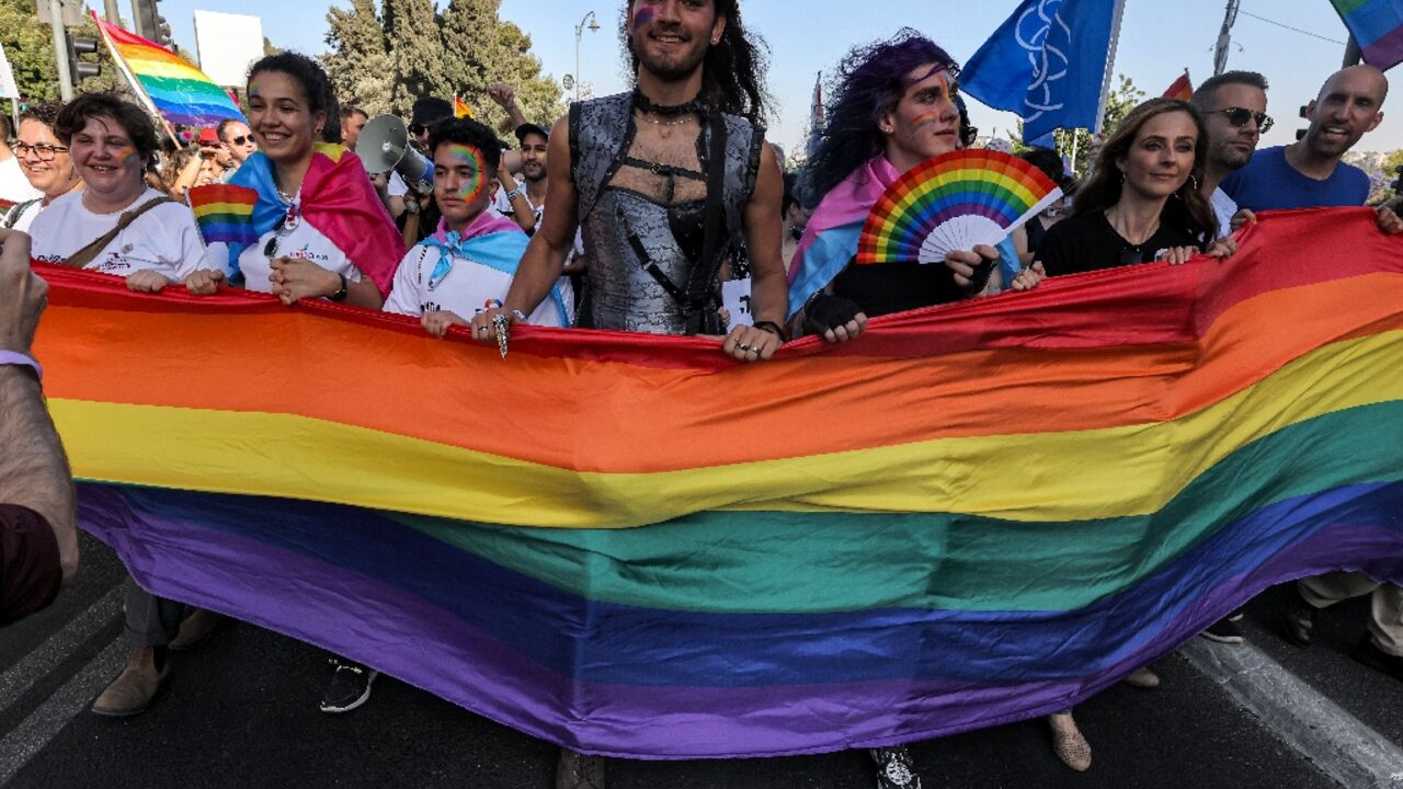 Participants march with a giant rainbow banner during the annual Jerusalem Pride Parade Participants march with a giant rainbow banner during the annual Jerusalem Pride Parade