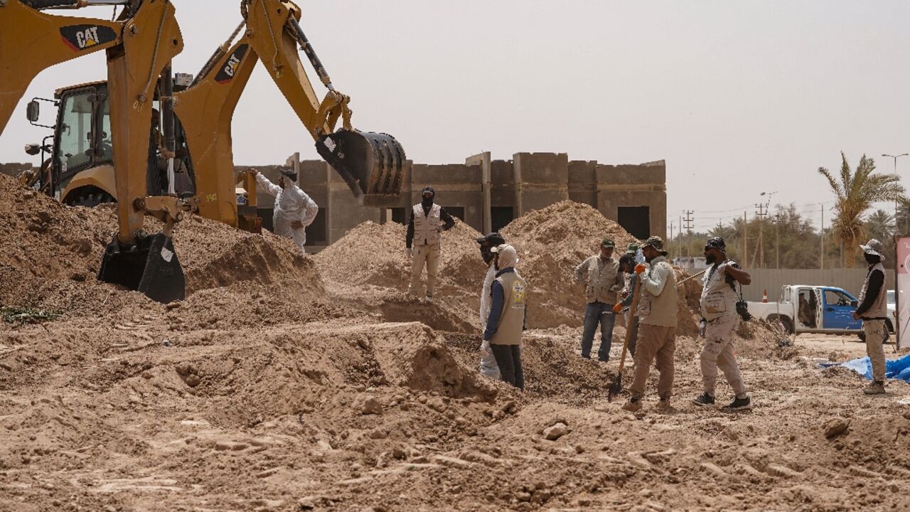 A backhoe digs up earth at the site of a mass grave, discovered by chance when property developers wanted to prepare the land for construction, in the central city of Najaf A backhoe digs up earth at the site of a mass grave, discovered by chance when property developers wanted to prepare the land for construction, in the central city of Najaf