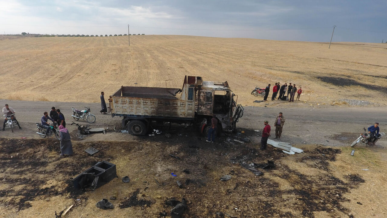 An aerial picture shows Syrian locals near a destroyed truck at the spot where Abu Hassan al-Muhajir, Islamic State spokesman, was reportedly killed in a raid in the village of Ayn al-Bayda near Jarablus, Syria, Oct. 28, 2019.